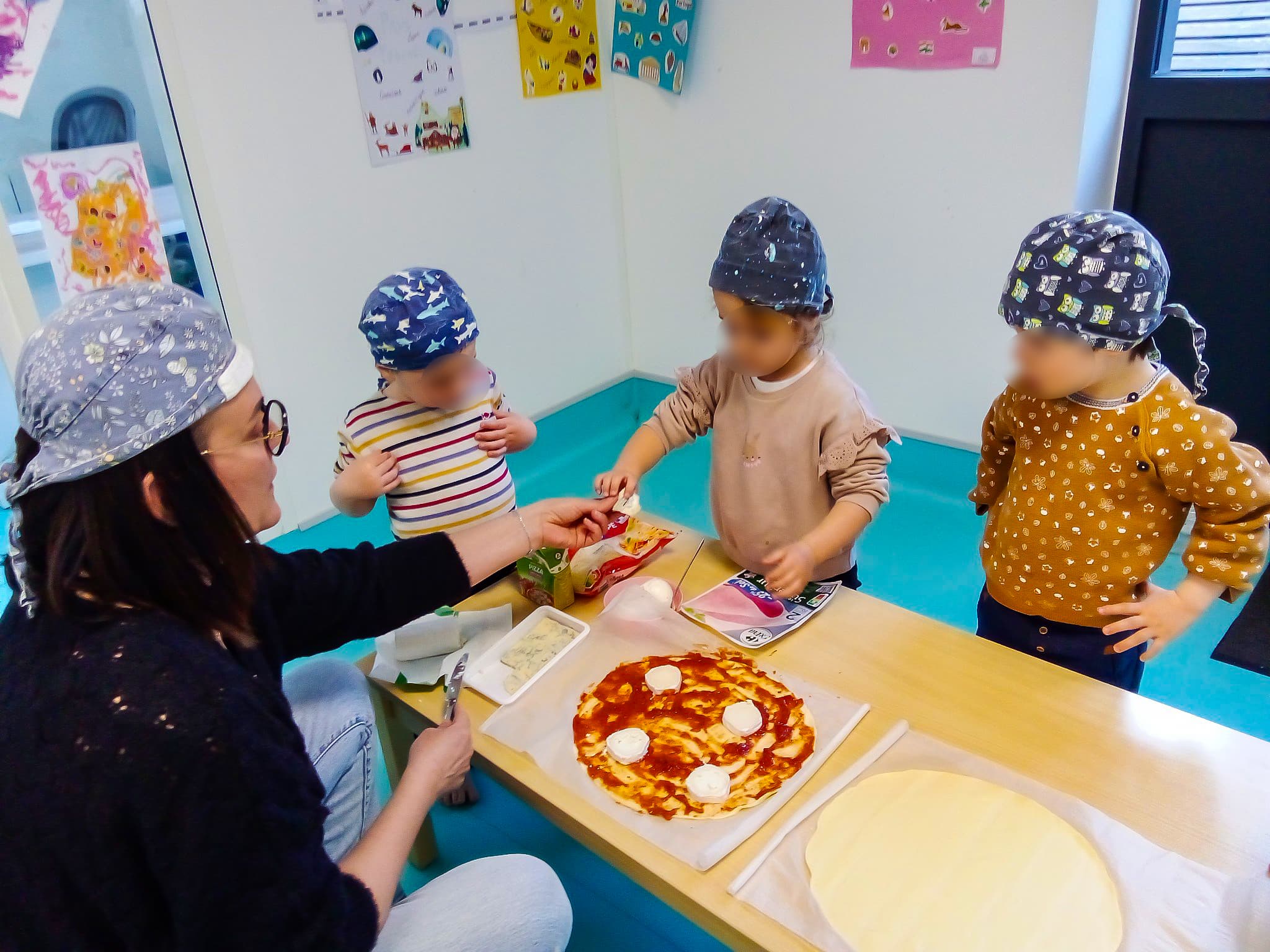 Les enfants cuisinent une pizza à la crèche.